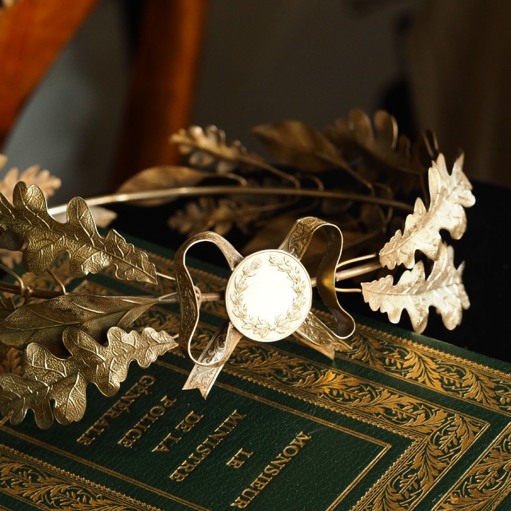 A 19th-century silver gilt foliate crown featuring detailed oak leaves, acorns, laurel leaves, and a central ribbon bow medallion. View XXII