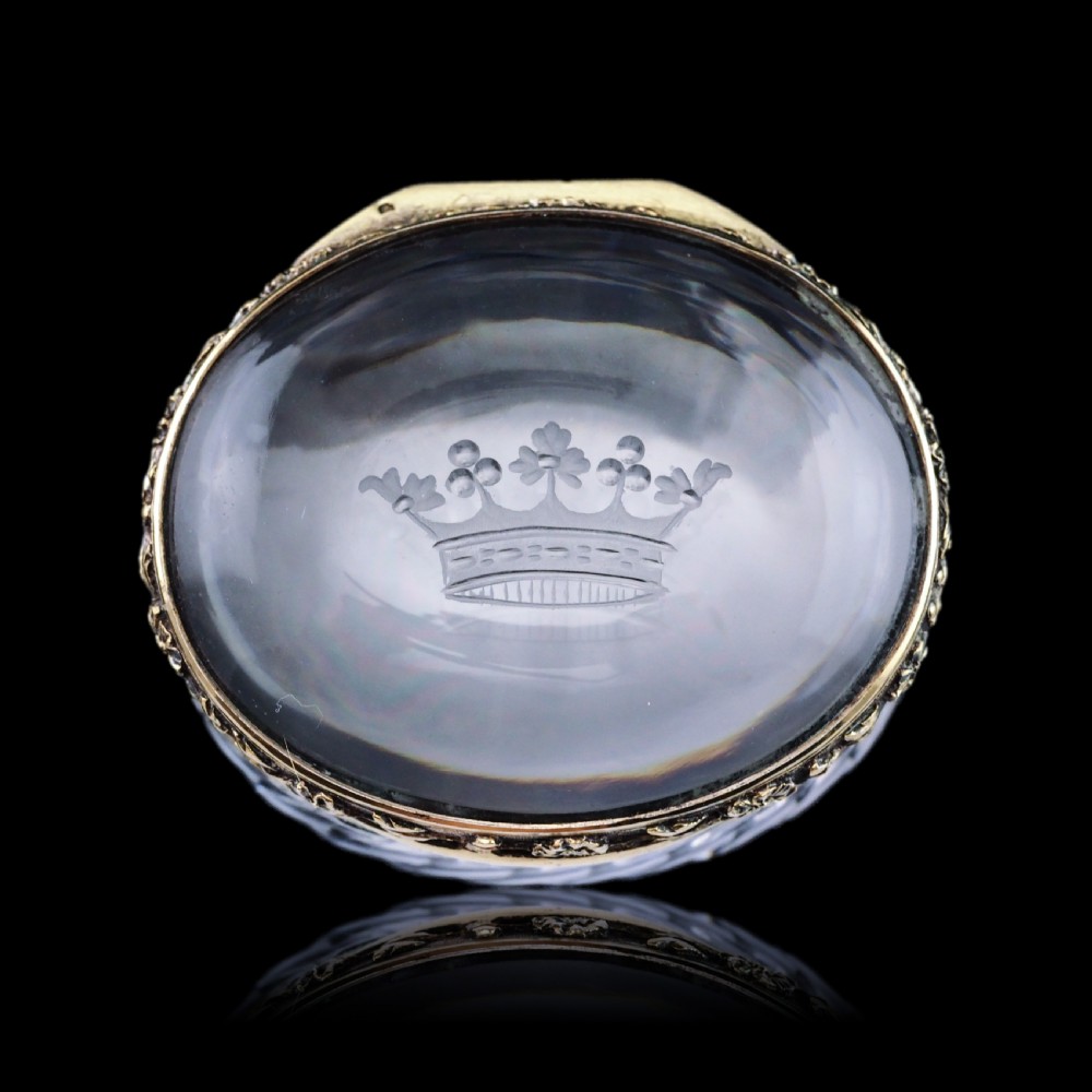 An oval cut crystal box featuring a gilt silver rim and a transparent glass lid etched with a nobility coronet crest. View III