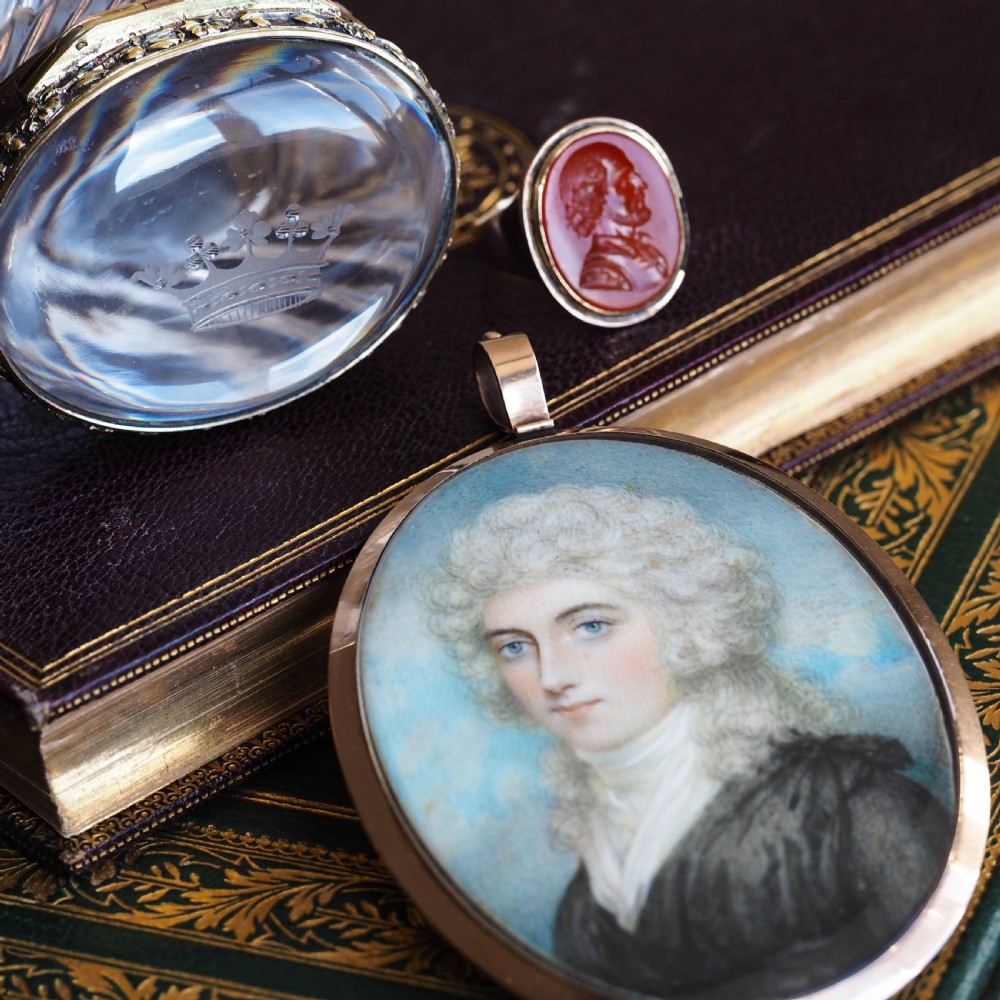 An oval cut crystal box featuring a gilt silver rim and a transparent glass lid etched with a nobility coronet crest. View V