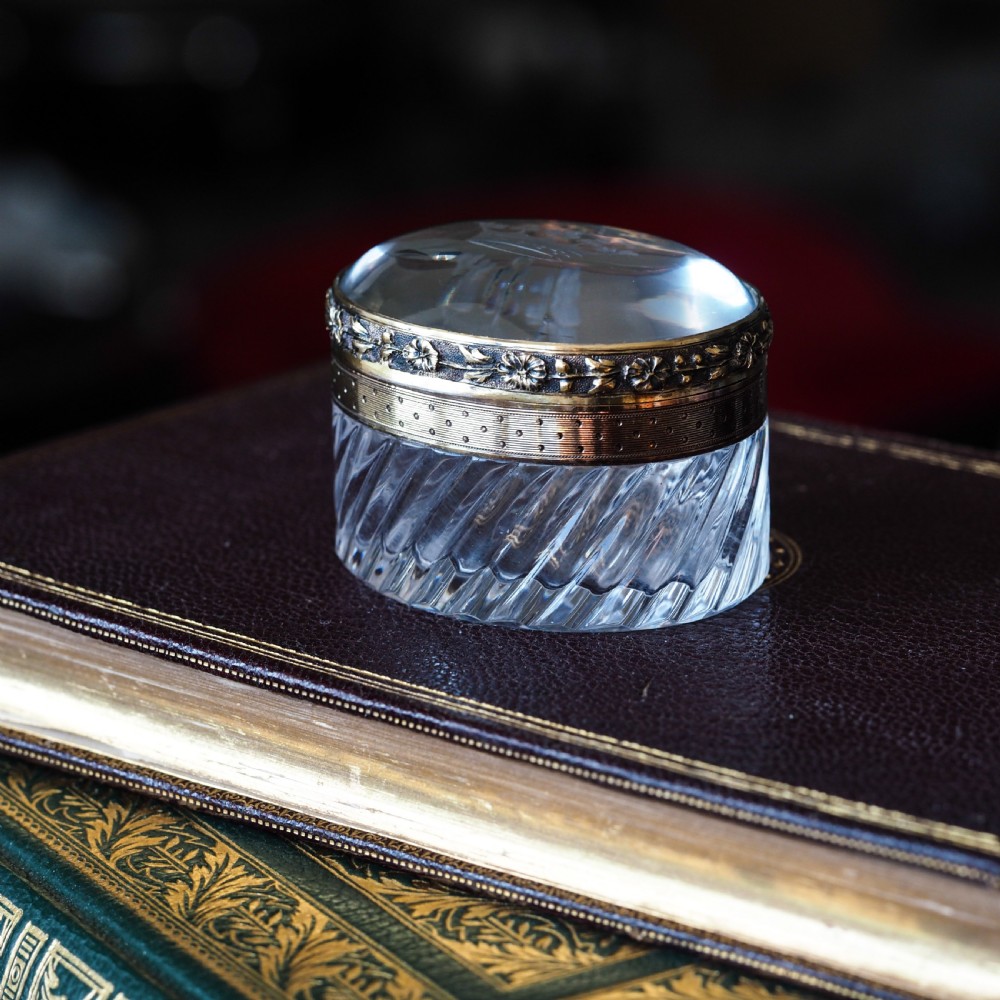 An oval cut crystal box featuring a gilt silver rim and a transparent glass lid etched with a nobility coronet crest. View XV