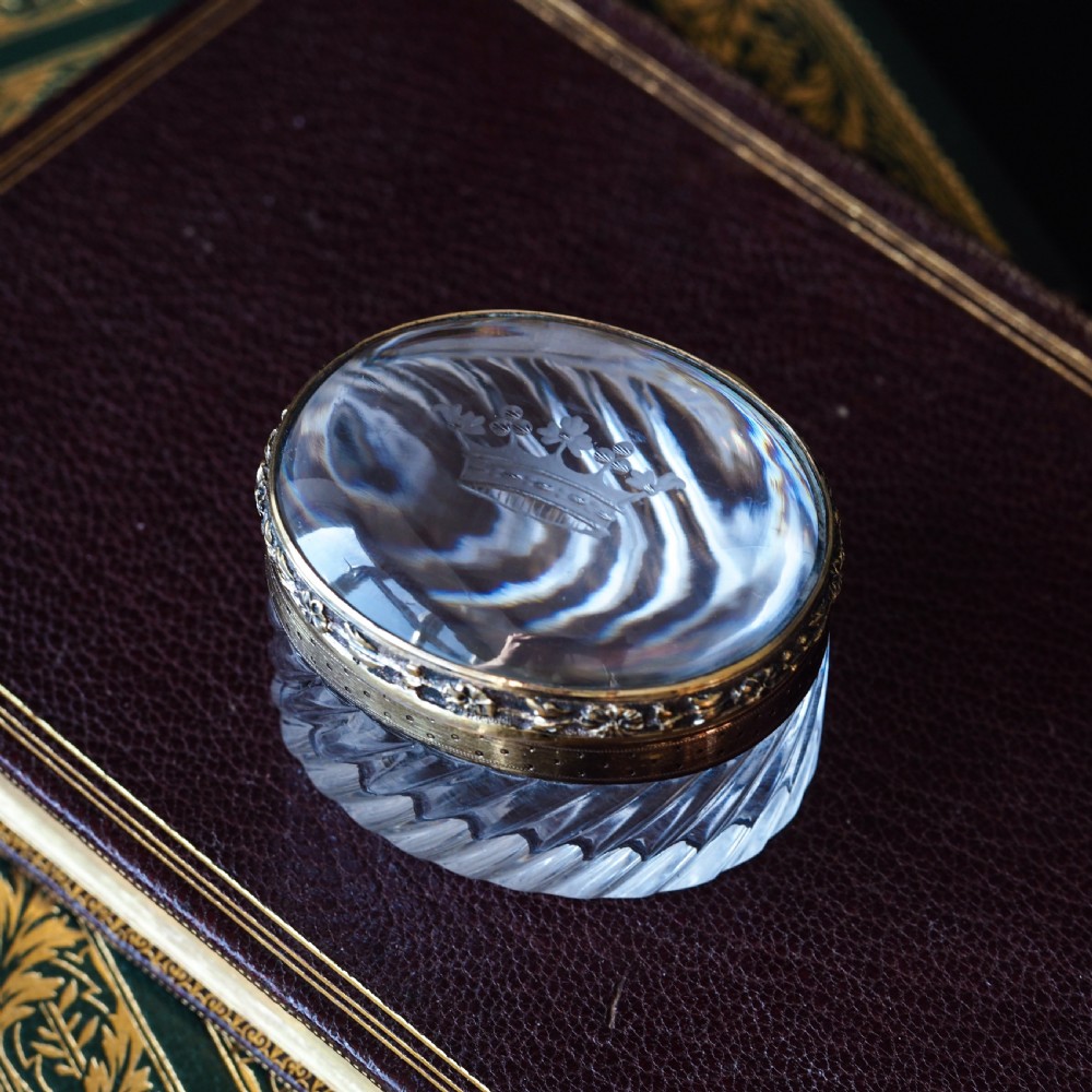 An oval cut crystal box featuring a gilt silver rim and a transparent glass lid etched with a nobility coronet crest. View XVI