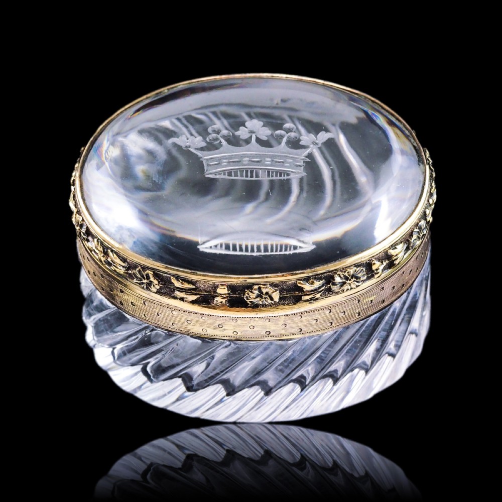 An oval cut crystal box featuring a gilt silver rim and a transparent glass lid etched with a nobility coronet crest. View XX