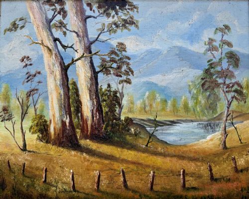 fig 1. A mid-century oil landscape painting depicting tall gum trees beside a lake against blue mountains, framed in a gilt and fabric-lined wooden frame.