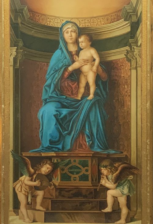 fig 2. A framed antique religious art print depicting the Madonna and Child within a gilt arched alcove above two musical cherubs, set in a dark moulded frame.