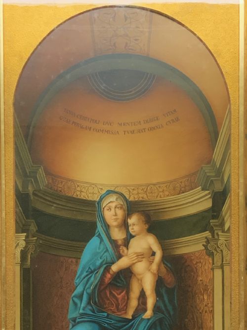 fig 3. A framed antique religious art print depicting the Madonna and Child within a gilt arched alcove above two musical cherubs, set in a dark moulded frame.