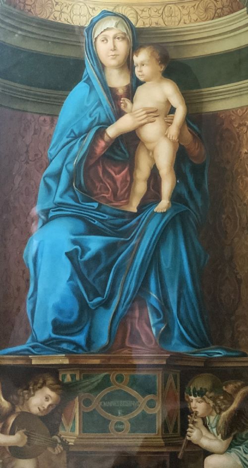 fig 4. A framed antique religious art print depicting the Madonna and Child within a gilt arched alcove above two musical cherubs, set in a dark moulded frame.