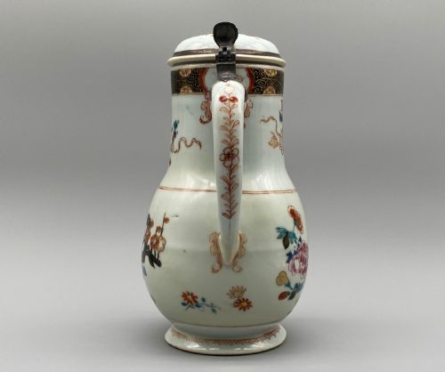 fig 5. An 18th-century Chinese porcelain jug with hand-painted Famille Rose floral enamels, a metal-mounted lid, and a loop handle.