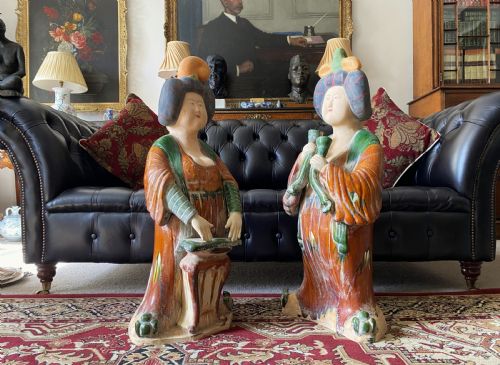 fig 1. A pair of large Sancai glazed ceramic sculptures depicting Tang Dynasty style female court musicians in orange, green, and cream robes.