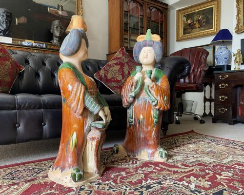 fig 2. A pair of large Sancai glazed ceramic sculptures depicting Tang Dynasty style female court musicians in orange, green, and cream robes.