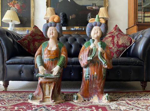 fig 3. A pair of large Sancai glazed ceramic sculptures depicting Tang Dynasty style female court musicians in orange, green, and cream robes.