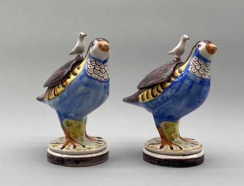 fig 4. A pair of 18th-century Spanish tin-glazed faience tureens fashioned as partridges with hand-painted blue, yellow, and brown plumage and small bird finials on their removable covers.