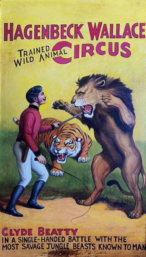 fig 1. A framed mid-twentieth-century oil painting depicting a lion tamer confronting a roaring lion and a tiger against a yellow background with bold red circus lettering.