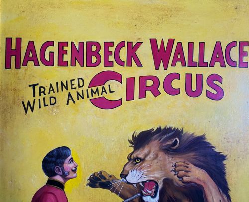 fig 2. A framed mid-twentieth-century oil painting depicting a lion tamer confronting a roaring lion and a tiger against a yellow background with bold red circus lettering.
