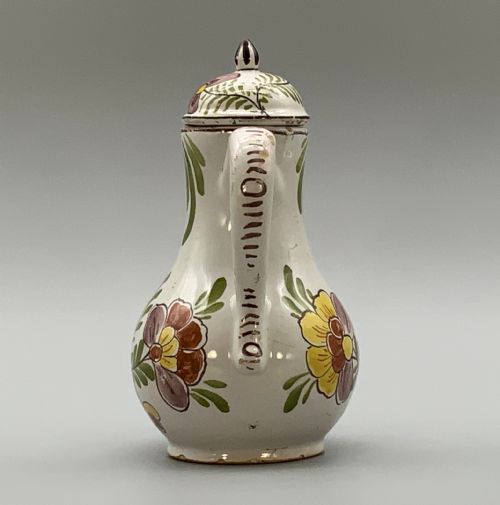 fig 4. An 18th-century Dutch Delft tin-glazed ceramic coffee pot decorated with polychrome floral motifs and a central blue maritime landscape medallion.