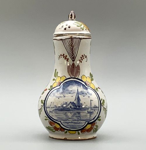 fig 6. An 18th-century Dutch Delft tin-glazed ceramic coffee pot decorated with polychrome floral motifs and a central blue maritime landscape medallion.