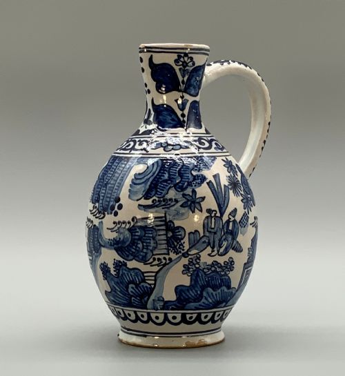 fig 3. An antique Dutch Delftware ceramic jug decorated with cobalt blue hand-painted Chinoiserie figures and botanical motifs against a white tin glaze.
