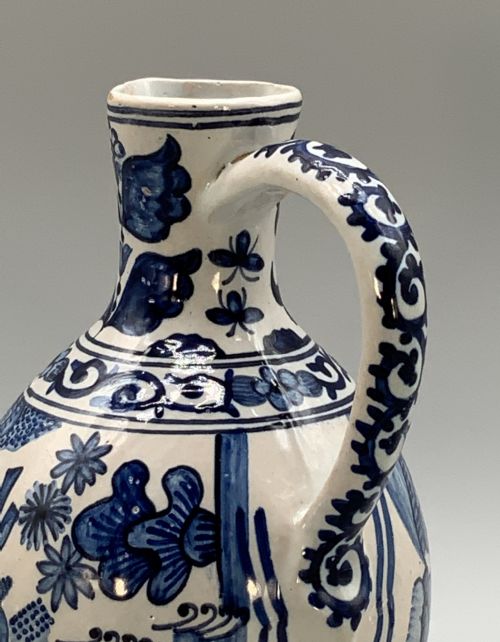 fig 6. An antique Dutch Delftware ceramic jug decorated with cobalt blue hand-painted Chinoiserie figures and botanical motifs against a white tin glaze.