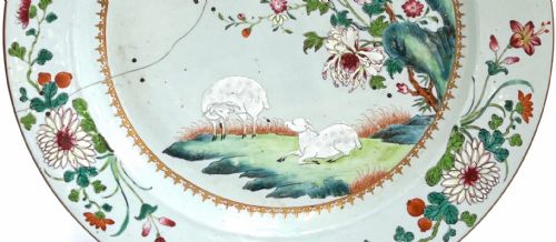 fig 3. A large circular Chinese export porcelain charger plate hand-painted with famille rose floral motifs, rockwork, and two white sheep on a pale background.
