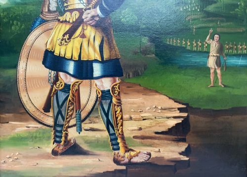 fig 5. An antique framed oil painting depicting Goliath clad in ornate gold and blue armour holding a spear, with David standing across a stream in the background.