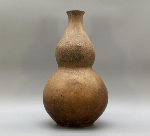 fig 2. A large terracotta ceramic vessel featuring a double gourd profile and a weathered brown unglazed finish.