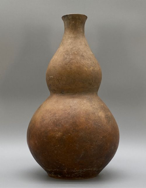 fig 3. A large terracotta ceramic vessel featuring a double gourd profile and a weathered brown unglazed finish.