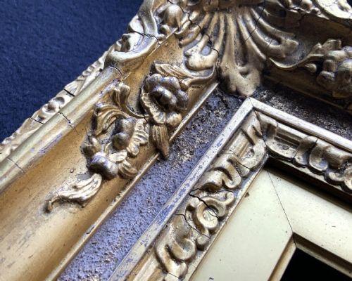 fig 7. An ornate 19th-century gold giltwood picture frame featuring intricate moulded gesso floral and shell embellishments around a central rectangular aperture.