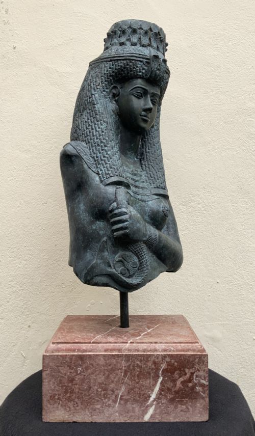 fig 2. A dark green patinated bronze bust of Cleopatra holding an asp, mounted on a rectangular pink marble base.