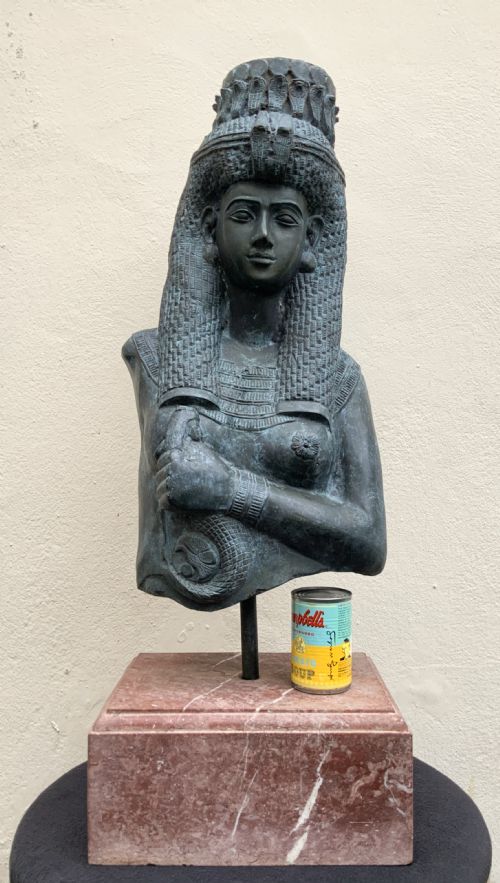 fig 3. A dark green patinated bronze bust of Cleopatra holding an asp, mounted on a rectangular pink marble base.