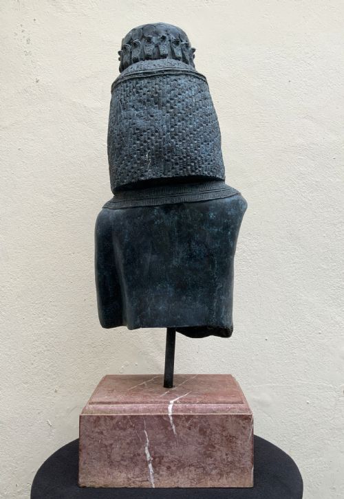 fig 5. A dark green patinated bronze bust of Cleopatra holding an asp, mounted on a rectangular pink marble base.