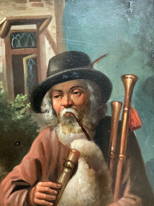 fig 6. An antique oil painting in a deep burr wood frame depicting an older bearded musician playing a bagpipe alongside a child holding an extended hat.
