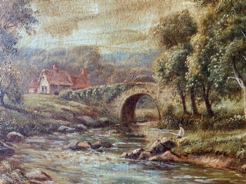 fig 7. An antique oil painting depicting a tranquil river flowing through a wooded landscape with a stone bridge and cottage in the background, framed in polished dark wood.