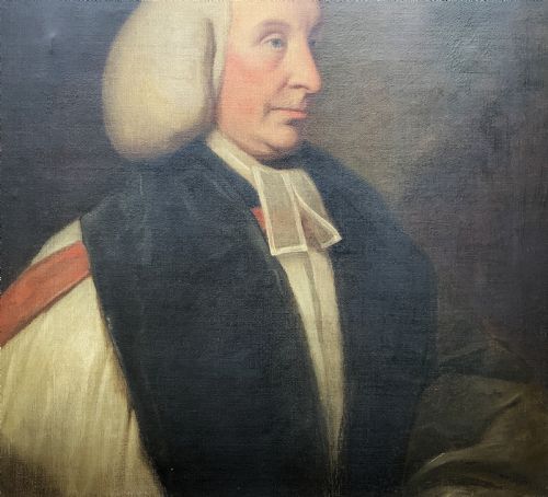 fig 5. An 18th-century oil portrait of a clergyman in a powdered wig and clerical bands, framed in a carved giltwood frame.