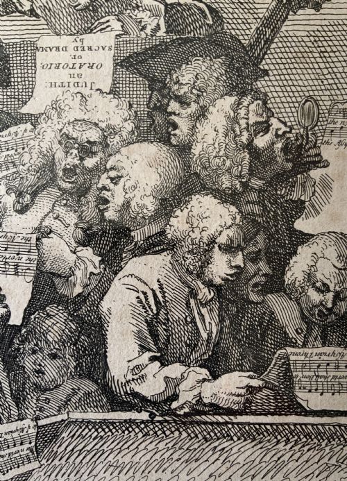 fig 5. A framed monochrome etching depicting a group of 18th-century choir singers holding music scores, set within a cream mount and a black and gold moulding frame.