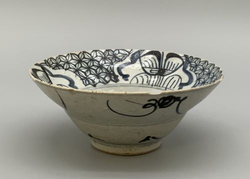 fig 4. A 17th-century Chinese Swatow porcelain bowl featuring hand-painted underglaze blue geometric and floral motifs on an off-white glazed surface.