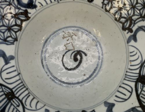 fig 6. A 17th-century Chinese Swatow porcelain bowl featuring hand-painted underglaze blue geometric and floral motifs on an off-white glazed surface.