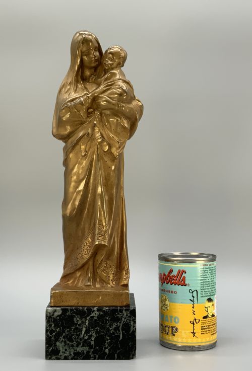 fig 1. A gilt bronze sculpture depicting the Madonna holding the infant Christ, mounted on a square dark green marbled base.