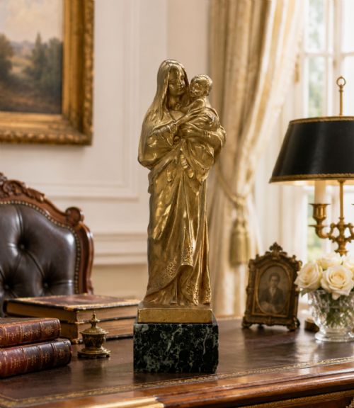 fig 2. A gilt bronze sculpture depicting the Madonna holding the infant Christ, mounted on a square dark green marbled base.