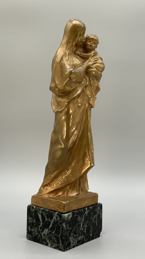 fig 3. A gilt bronze sculpture depicting the Madonna holding the infant Christ, mounted on a square dark green marbled base.