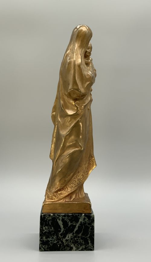 fig 4. A gilt bronze sculpture depicting the Madonna holding the infant Christ, mounted on a square dark green marbled base.