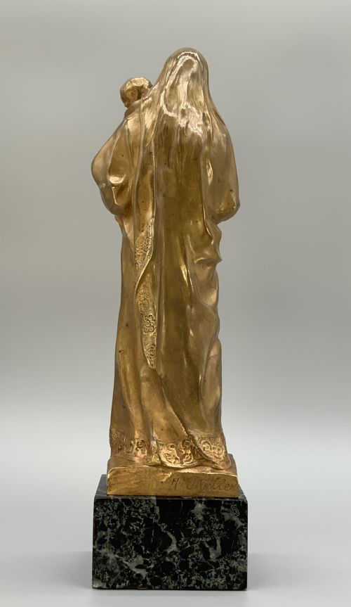 fig 5. A gilt bronze sculpture depicting the Madonna holding the infant Christ, mounted on a square dark green marbled base.