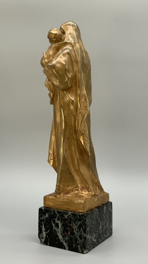 fig 6. A gilt bronze sculpture depicting the Madonna holding the infant Christ, mounted on a square dark green marbled base.