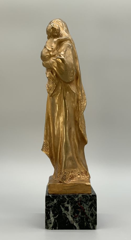 fig 7. A gilt bronze sculpture depicting the Madonna holding the infant Christ, mounted on a square dark green marbled base.