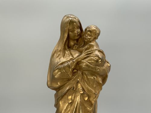 fig 9. A gilt bronze sculpture depicting the Madonna holding the infant Christ, mounted on a square dark green marbled base.