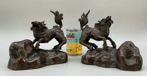 fig 2. A pair of patinated dark bronze Japanese mythical creature statues positioned on sculpted rocky bases.