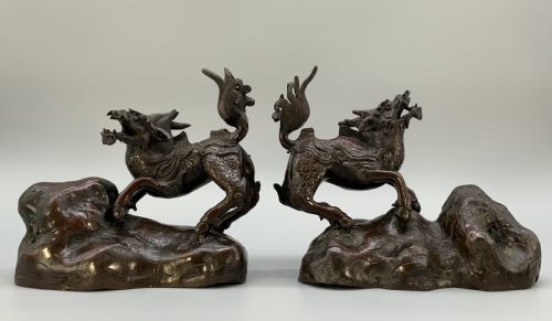 fig 3. A pair of patinated dark bronze Japanese mythical creature statues positioned on sculpted rocky bases.