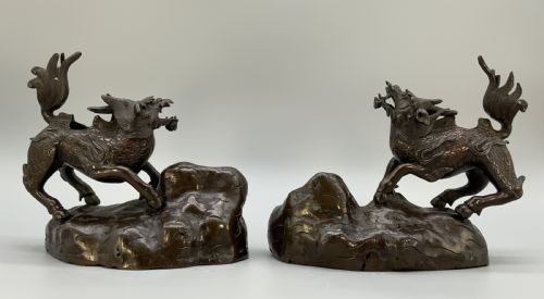 fig 6. A pair of patinated dark bronze Japanese mythical creature statues positioned on sculpted rocky bases.