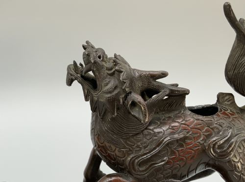fig 7. A pair of patinated dark bronze Japanese mythical creature statues positioned on sculpted rocky bases.