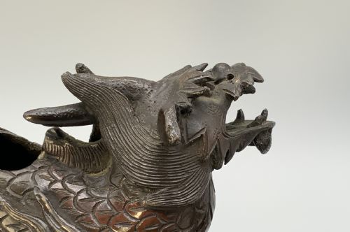 fig 8. A pair of patinated dark bronze Japanese mythical creature statues positioned on sculpted rocky bases.