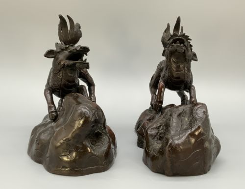 fig 9. A pair of patinated dark bronze Japanese mythical creature statues positioned on sculpted rocky bases.