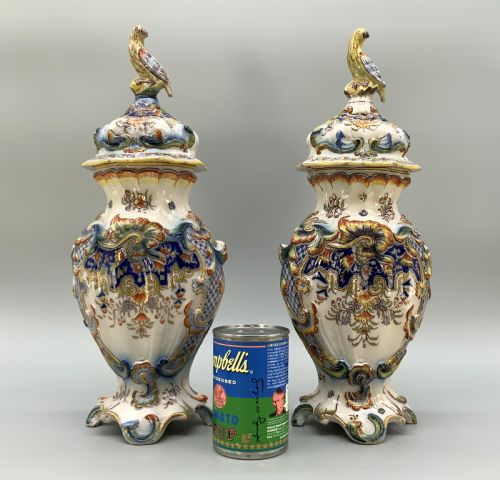 fig 2. A pair of ornate French faience lidded vases decorated with hand-painted polychrome florals, Rococo scrollwork moulding, and sculptural parrot finials.